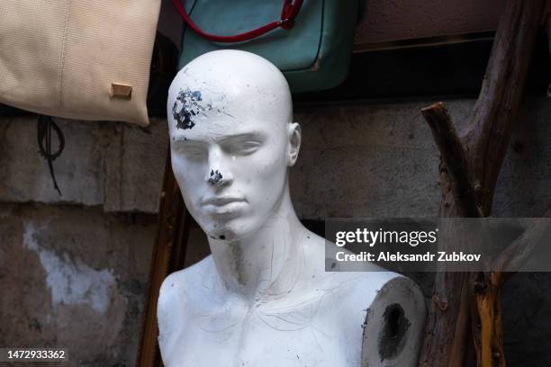 broken and abandoned mannequin, faded condition. a mannequin that is no longer used. the face of a broken mannequin in the used clothing market area. an old worn-out mannequin with cracks and breakages. - broken mannequin stock pictures, royalty-free photos & images