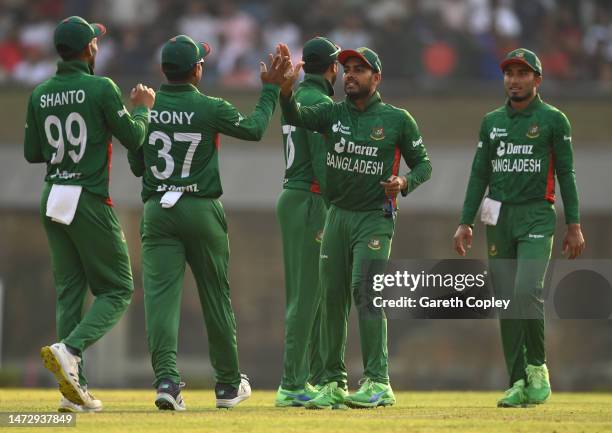 Mehidy Hasan Miraz of Bangladesh celebrates with team mates after dismissing Chris Jordan of England during the 2nd T20 International between...