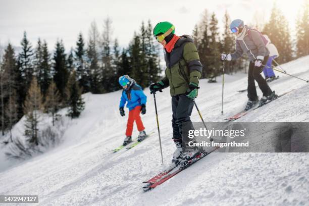 family skiing in mountains of european alps in austria - family skiing stock pictures, royalty-free photos & images