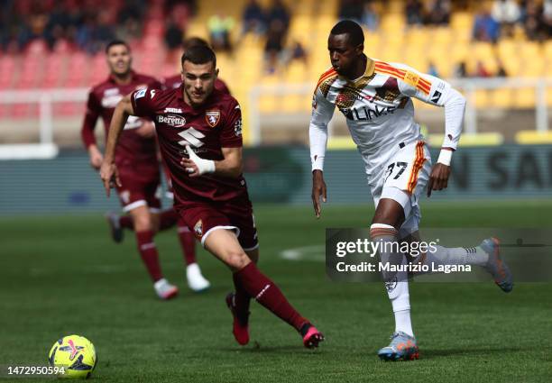 Assan Ceesay of Lecce competes for the ball with Alessandro Buongiorno of Torino during the Serie A match between US Lecce and Torino FC at Stadio...