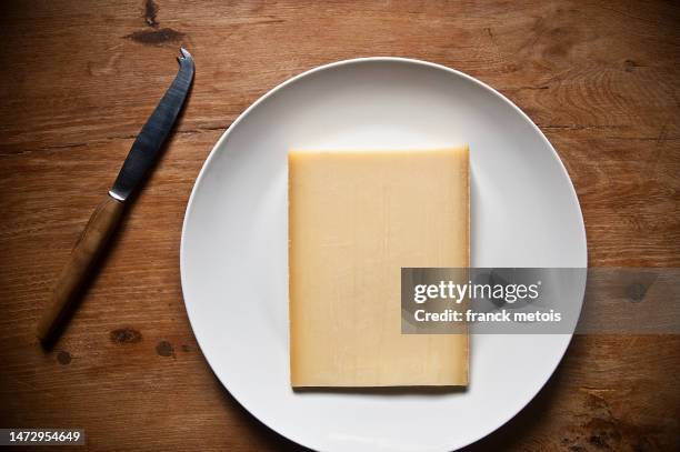 slice of comte cheese ( france) - comté stock pictures, royalty-free photos & images