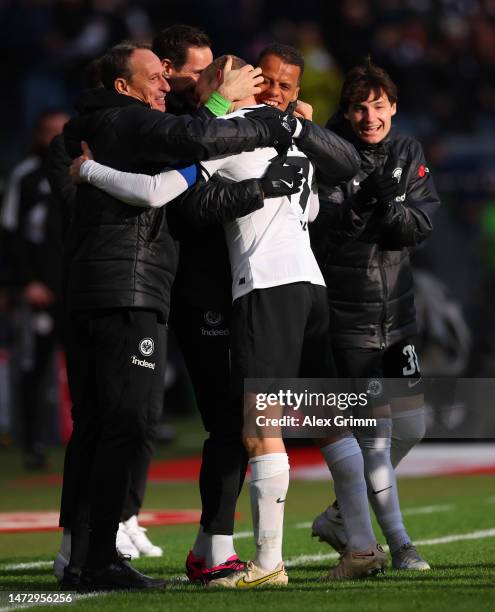 Sebastian Rode of Eintracht Frankfurt celebrates their team's first goal with with staff and teammates during the Bundesliga match between Eintracht...