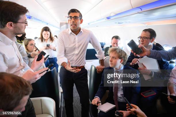 Britain's Prime Minister Rishi Sunak speaks with members of the media during a "huddle" onboard a plane bound for San Diego on March 12, 2023 in...