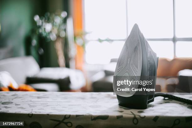 iron on a ironing board at home - tábua-de-passar-roupa imagens e fotografias de stock
