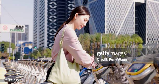 mujer alquilar un viaje en bicicleta - economía colaborativa fotografías e imágenes de stock