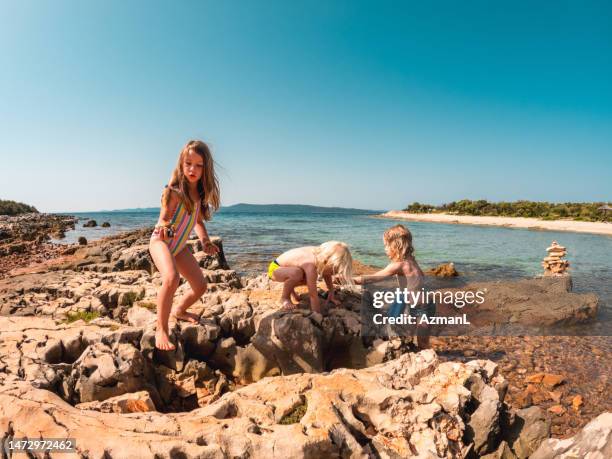 zwei jungen und ein mädchen entspannen sich am wasser - croatia girls stock-fotos und bilder