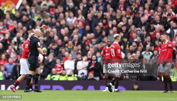 Casemiro of Manchester United is shown a red card by match referee Anthony Taylor during the Premier League match between Manchester United and...