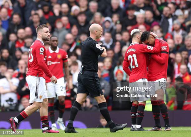 Casemiro of Manchester United is consoled by teammate Antony as he looks dejected after being shown a red card by match referee Anthony Taylor during...