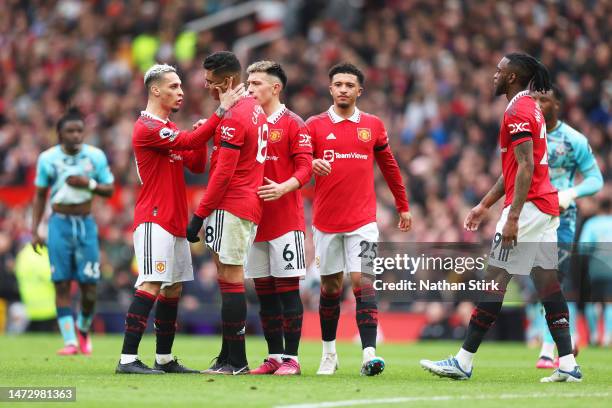 Casemiro of Manchester United is consoled by teammate Antony as he looks dejected leaving the pitch after being shown a red card during the Premier...