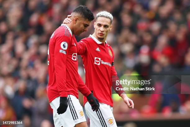 Casemiro of Manchester United is consoled by teammate Antony as he looks dejected leaving the pitch after being shown a red card during the Premier...