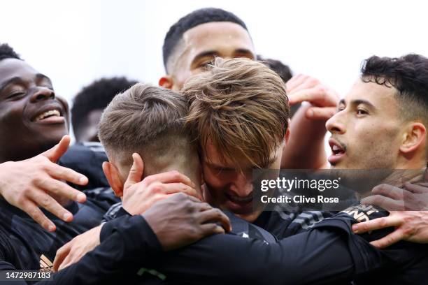 Martin Odegaard of Arsenal celebrates after scoring the team's third goal with teammates during the Premier League match between Fulham FC and...