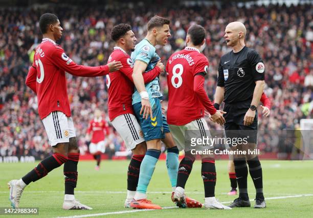 Players confront match referee Anthony Taylor during the Premier League match between Manchester United and Southampton FC at Old Trafford on March...