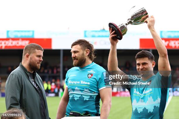 Ben Youngs the captain of Leicester holds aloft the Ed Slater trophy as former player Ed Slater looks on with Harry Wells following the Gallagher...
