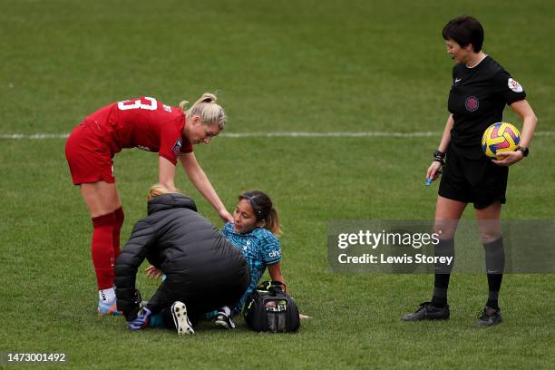 Gemma Bonner of Liverpool speaks with Mana Iwabuchi of Tottenham Hotspur as they receive medical treatment after picking up an injury before being...