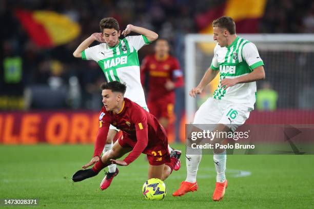 Paulo Dybala of AS Roma is challenged by Maxime Lopez and Davide Frattesi of US Sassuolo during the Serie A match between AS Roma and US Sassuolo at...