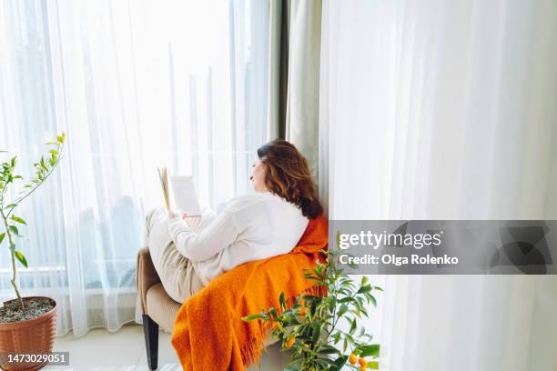 self education at home. female reading a book, prepare to exams and studying at home - curled up reading stock pictures, royalty-free photos & images