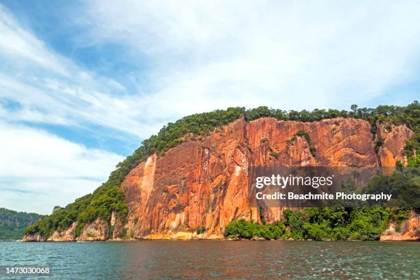 scenic view the red cliffs of berhala island in sandakan, sabah, malaysia - kota kinabalu beach stock pictures, royalty-free photos & images