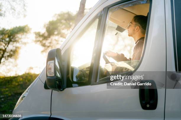 young boy driving a campervan in the middle of the forest, campervan backgrounds, vanlife themes - mini van stock pictures, royalty-free photos & images