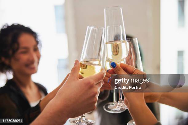 nahaufnahme von freunden beim anstoßen mit champagnergläsern auf der hausparty - champagnerglas stock-fotos und bilder