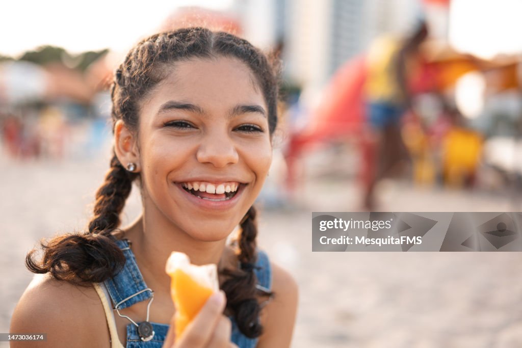 Porträt eines Teenager-Mädchens, das im Freien Eis am Stiel isst