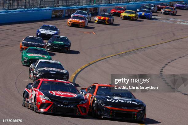 Christopher Bell, driver of the Rheem Toyota, and Ross Chastain, driver of the Kubota Chevrolet, race during the NASCAR Cup Series United Rentals...