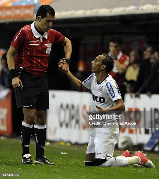 Referee Enrique Osses of Chile helps Liedson of Corinthians during a match between Boca Juniors and Corinthians as part of the first leg of the...