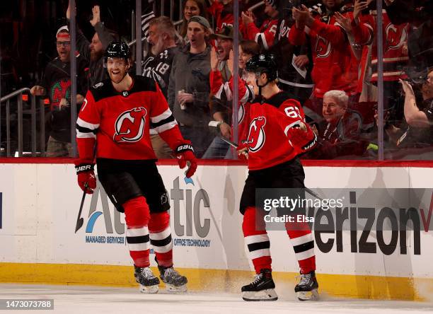 Jesper Bratt of the New Jersey Devils celebrates his goal during the first period against the Carolina Hurricanes with teammate Dougie Hamilton at...