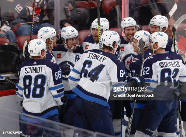 Teammates congratulate Mark Scheifele of the Winnipeg Jets after he scored the game winning goal against the Florida Panthers in overtime at the FLA...