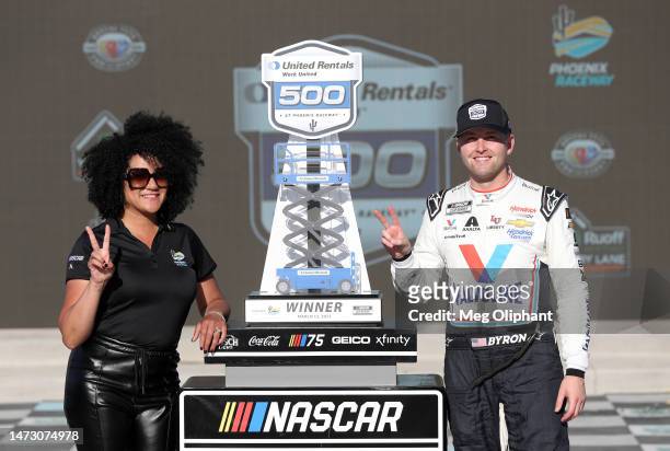 William Byron, driver of the Valvoline Chevrolet, and Latasha Causey, president of Phoenix Raceway pose for photos in victory lane after winning the...