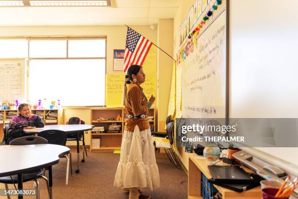 navajo indigenous teacher facing the whiteboard in the classroom - national flag day stock pictures, royalty-free photos & images