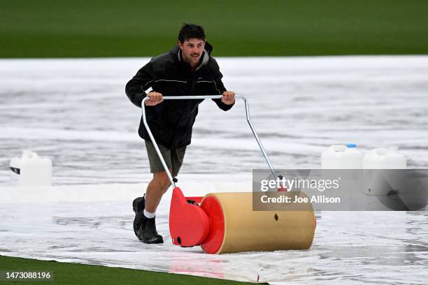 Groundskeeper removes water from the covers during day five of the First Test match in the series between New Zealand and Sri Lanka at Hagley Oval on...