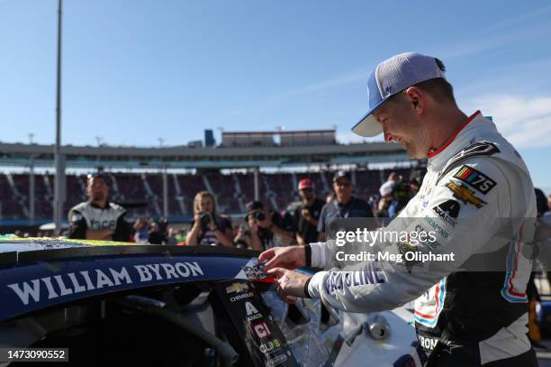 William Byron, driver of the Valvoline Chevrolet, places the winner sticker on his car in victory lane after winning the NASCAR Cup Series United...