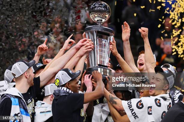 The Purdue Boilermakers celebrate with the trophy after defeating the Penn State Nittany Lions in the Big Ten Basketball Tournament Championship game...