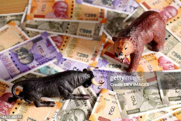 bear and bull figurines on indian currency notes - bull bear stock pictures, royalty-free photos & images