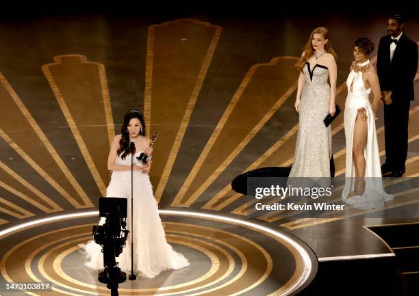 Michelle Yeoh accepts the Best Actress award for "Everything Everywhere All at Once" from Jessica Chastain and Halle Berry onstage during the 95th...