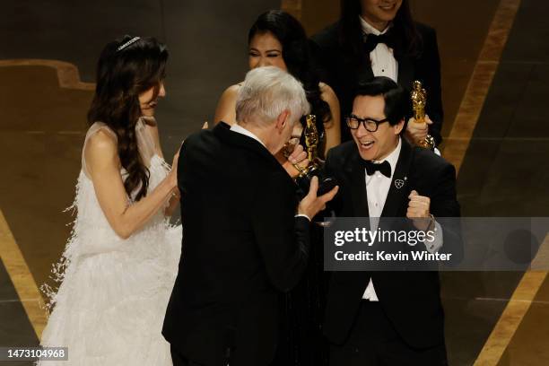 Michelle Yeoh and Ke Huy Quan accept the award for Best Picture for "Everything Everywhere All at Once" from Harrison Ford onstage during the 95th...