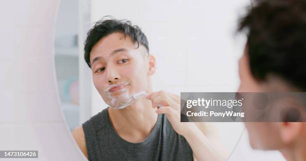 hombre usa maquinilla de afeitar para afeitarse - maquinilla de afeitar fotografías e imágenes de stock