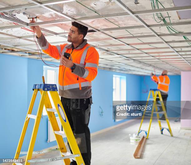 electricians testing ceiling fixtures - ladder stock pictures, royalty-free photos & images