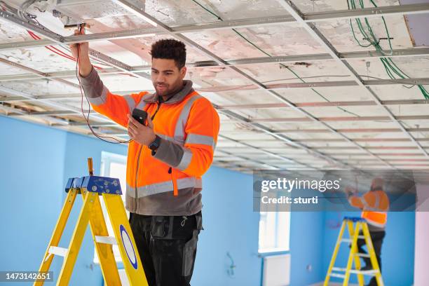 electricians testing ceiling fixtures - installing ceiling light fixture stock pictures, royalty-free photos & images