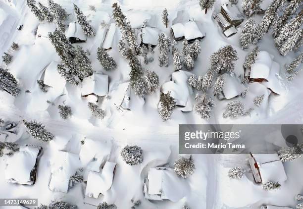 In an aerial view, snow covers roofs next to snowbanks piled up from new and past storms in the Sierra Nevada mountains, in the wake of an...