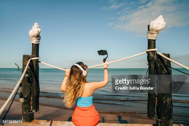young woman traveler taking photos with selfie stick - selfiestick stock-fotos und bilder