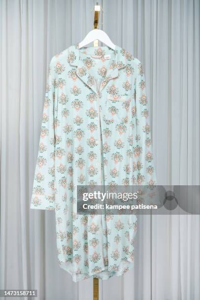 close-up of dress hanging on clothanger against white cutrain background - floral pattern dress stock pictures, royalty-free photos & images