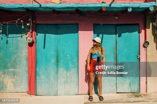 young woman traveler over vibrant colorful wall - isla holbox fotografías e imágenes de stock