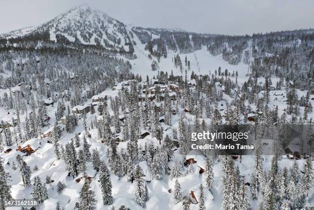 In an aerial view, snow from new and past storms blankets houses and condominiums near Mammoth Mountain chair lifts in the Sierra Nevada mountains,...