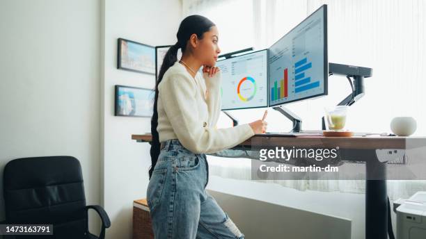 woman with back pain working at standing desk home office - working from home imagens e fotografias de stock
