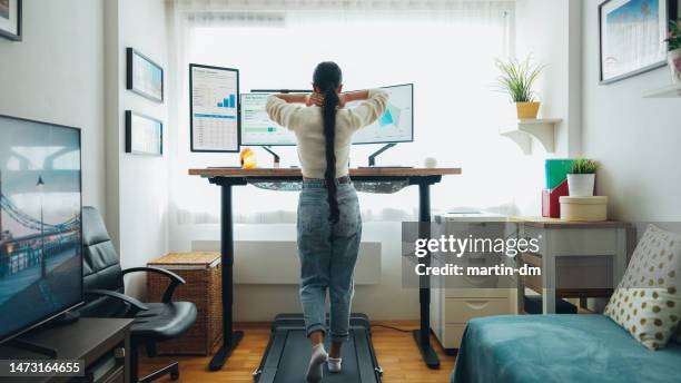 mujer en la oficina en casa camina debajo de la cinta de correr del escritorio - treadmill fotografías e imágenes de stock