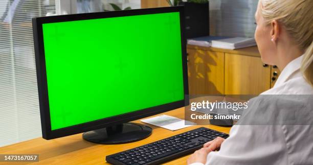 frau schaut auf computermonitor - computer monitor green screen stock-fotos und bilder