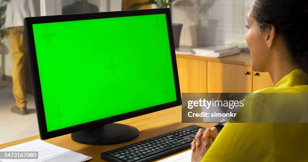 woman looking at computer monitor - computer monitor green screen stock pictures, royalty-free photos & images