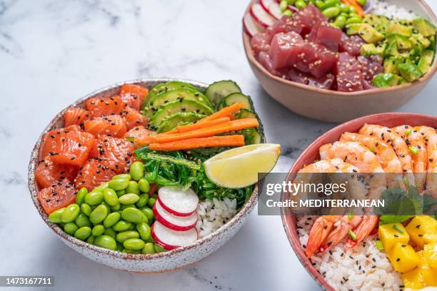 poke bowls, salmon poke, tuna poke and shrimp poke on white marble - pokes stock pictures, royalty-free photos & images