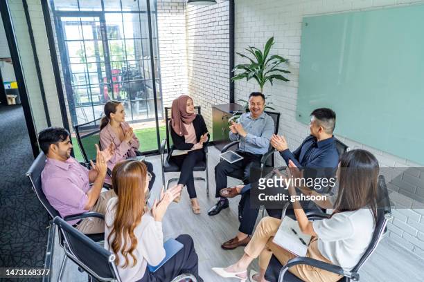 business team from multiracial sitting in circle and discussing - workplace wellbeing stock pictures, royalty-free photos & images